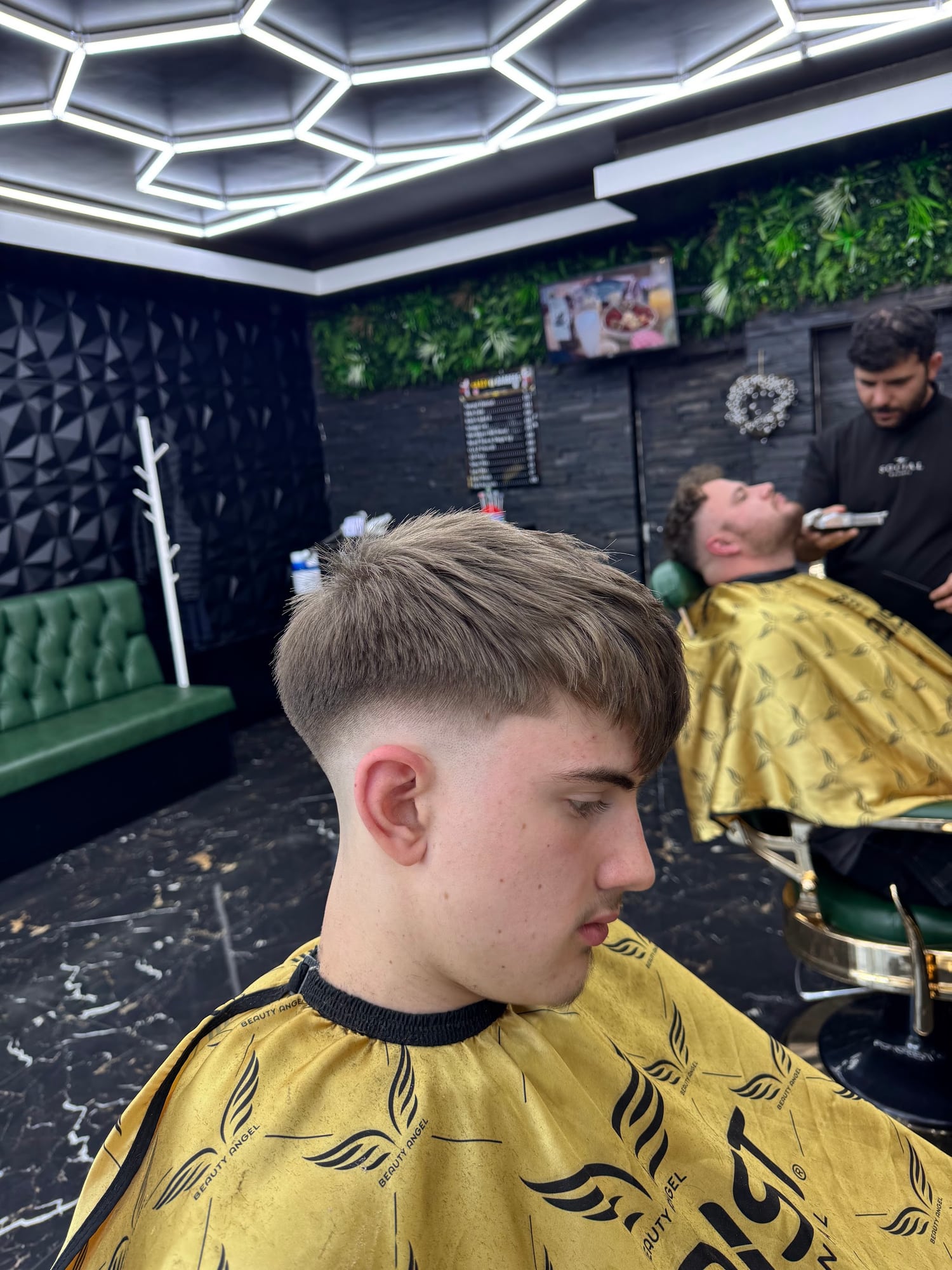 Finished haircut with the Hardy Barbers team at work in the background